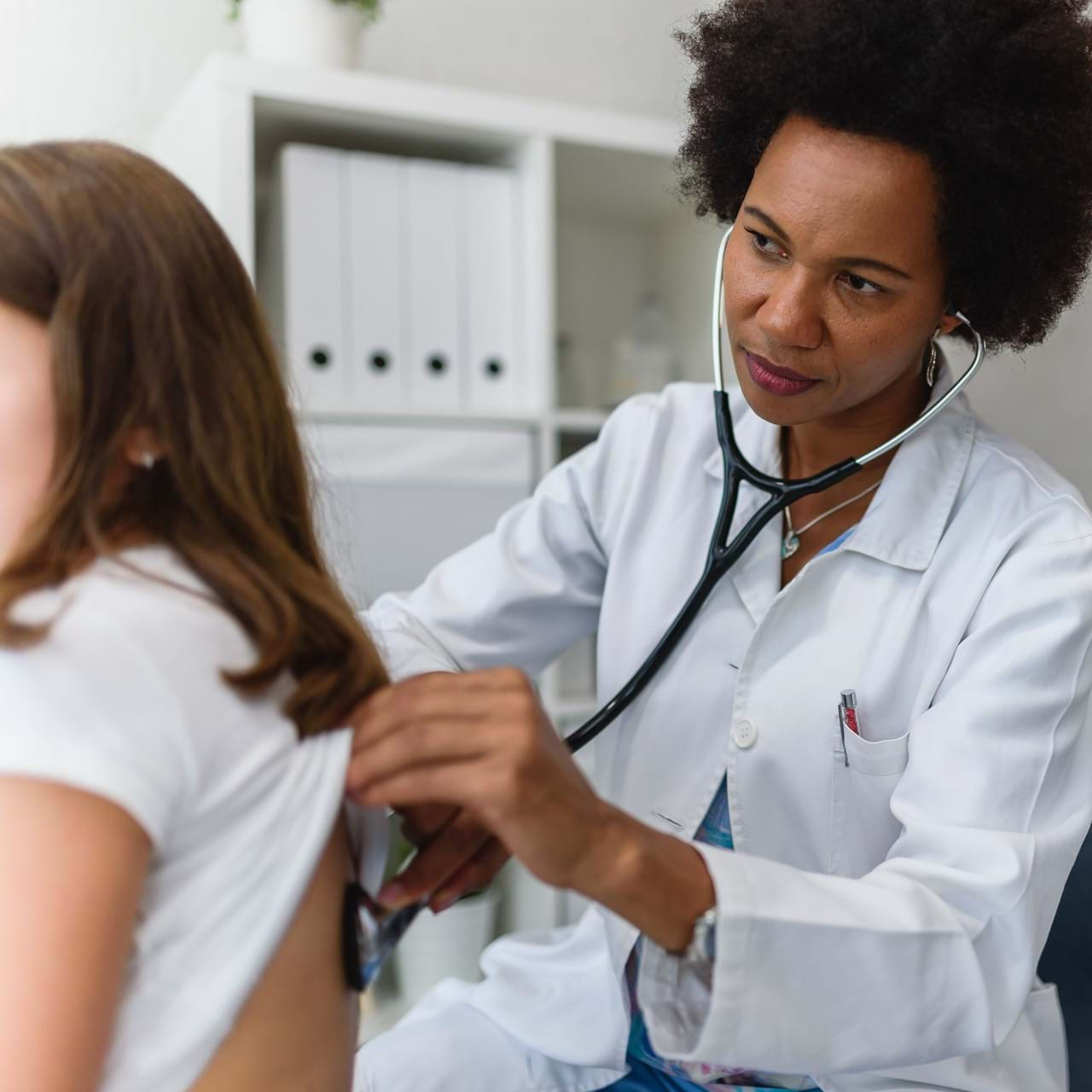 Doctor listening to breath of child